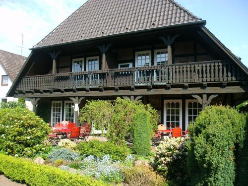 uma grande casa com uma varanda e um jardim em Landhaus Zum Heidewanderer em Bad Bevensen