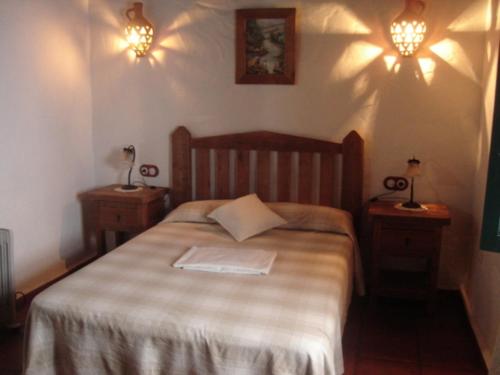 Un dormitorio con una cama grande con dos mesitas de noche. en El Peñón, en Zahara de la Sierra