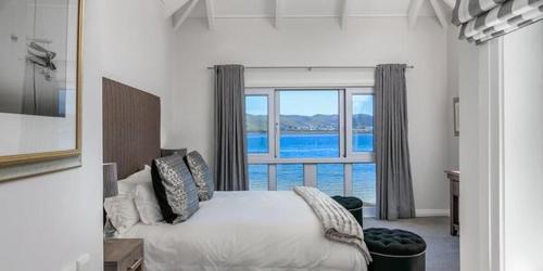 a bedroom with a bed and a large window at On the water - Thesen in Knysna