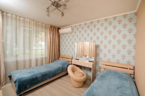 Habitación hospitalaria con 2 camas y TV en Aurooms, en Novokuznetsk