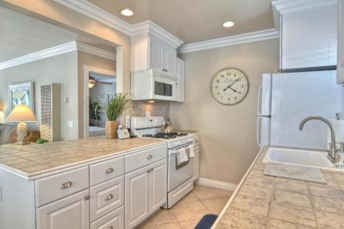 a kitchen with white cabinets and a clock on the wall at Monterey C in San Clemente