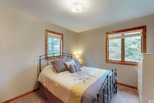a bedroom with a bed and two windows at Conrad Vista Waterfront Home in Laclede