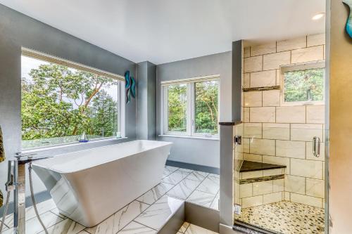 a bathroom with a large tub and windows at 6 Bed 4 Bath Vacation home in Eastsound in Eastsound