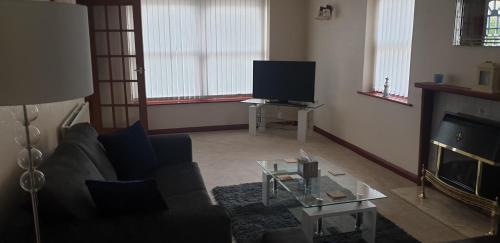 a living room with a couch and a tv at Swales cottage in Whitby