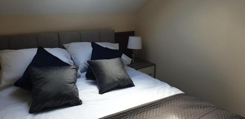 - un lit avec des oreillers en noir et blanc dans l'établissement Swales cottage, à Whitby