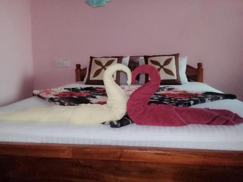 two swans sitting on top of a bed at Ella Summer Lesser in Ella