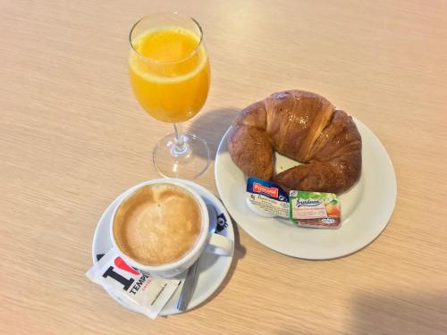 a plate with a cup of coffee and a glass of orange juice at Hotel Hormilla in Hormilla