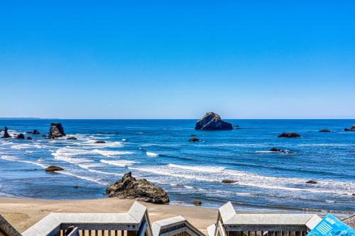 a beach with rocks in the ocean on a clear day at Tidal Links - 4 Bed 3 Bath Vacation home in Bandon Dunes in Bandon