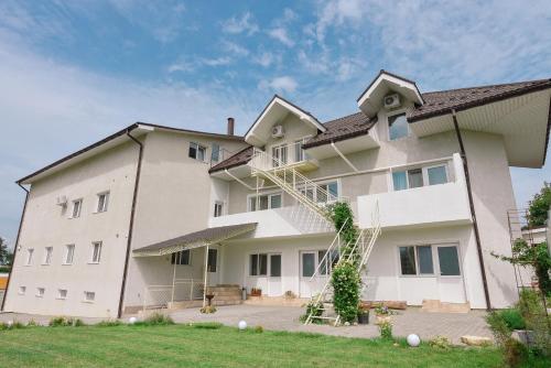 Un grand bâtiment blanc avec une échelle dans l'établissement Appartments near 7 km 5001155, à Odessa