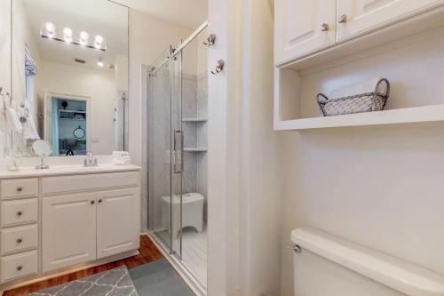a white bathroom with a shower and a sink at Destiny Beach Villa #6A in Destin