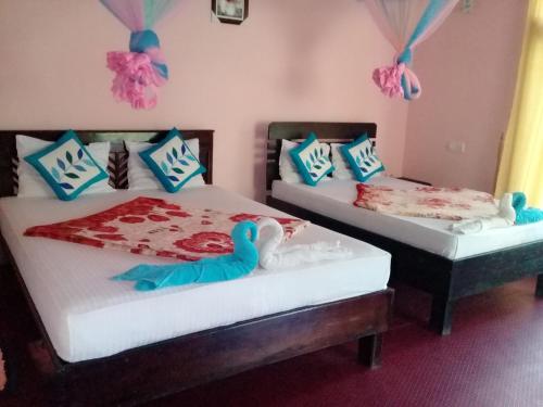 two twin beds in a room with a toy duck on them at Ella Summer Lesser in Ella