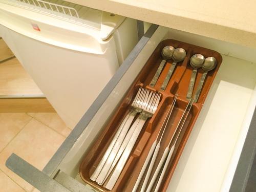 a drawer with knives and utensils in a kitchen at Rio desert view apartment in Arad