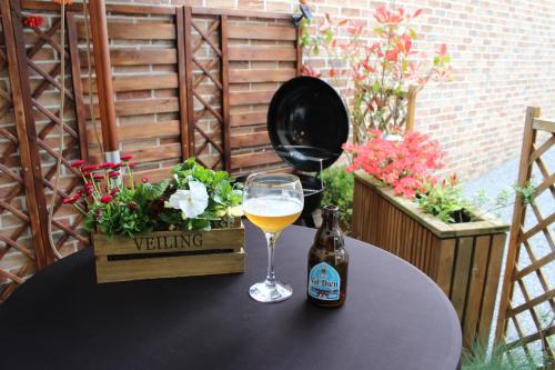 a glass of wine and a bottle of beer on a table at Éco Gîtes Aubelrando & villa-bocage in Aubel