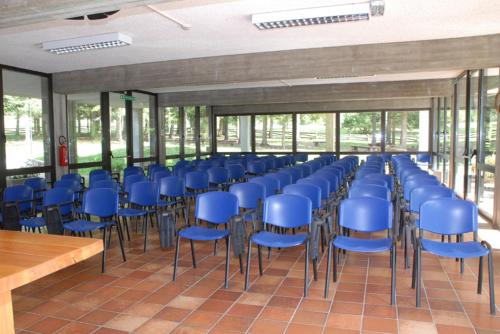 a row of blue chairs in a room with windows at Casa Santa Maria in Folgaria