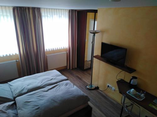 pokój hotelowy z łóżkiem i telewizorem w obiekcie Die Krone w mieście Ratingen