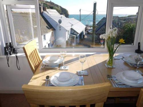 a dining room table with a view of the ocean at Jimmer's Loft in Cadgwith