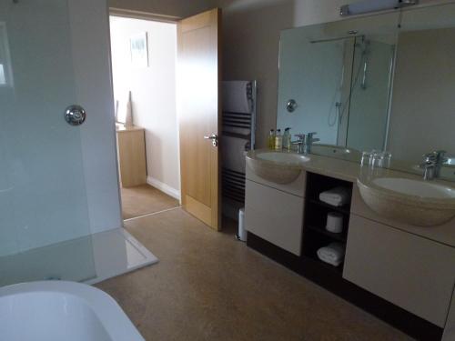 a bathroom with two sinks and a toilet and a mirror at Boathouse Hotel in Hythe