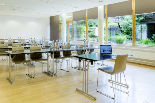 a conference room with a table and chairs and a laptop at Hotel Kreuz Lenk in Lenk