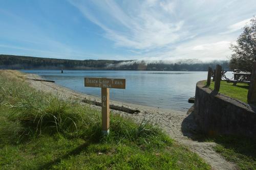 a sign in the grass next to a body of water at Resort at Port Ludlow in Port Ludlow