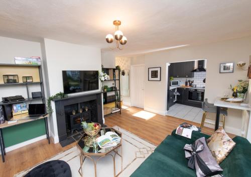 uma sala de estar com um sofá verde e uma lareira em Forge House em Wallingford