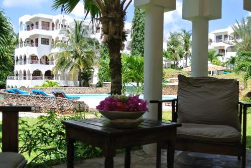 a bowl of flowers on a table in front of a resort at Amani Residence Beverly Suites in Malindi