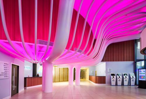 un grand plafond rose dans un bâtiment équipé de machines dans l'établissement Atrium Hotel Heathrow, à Hillingdon