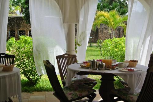 a table and chairs with food on it at Amani Residence Beverly Suites in Malindi