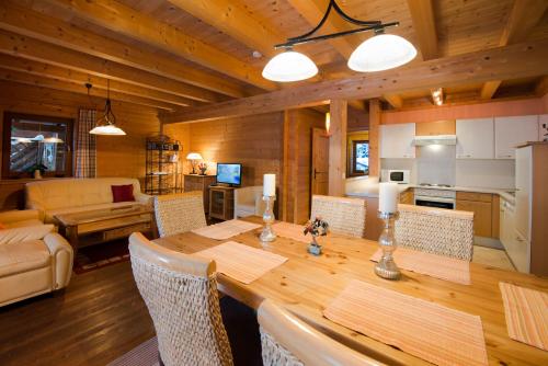 eine Küche und ein Wohnzimmer mit einem Holztisch und Stühlen in der Unterkunft Feriendorf Wildschönau in Niederau