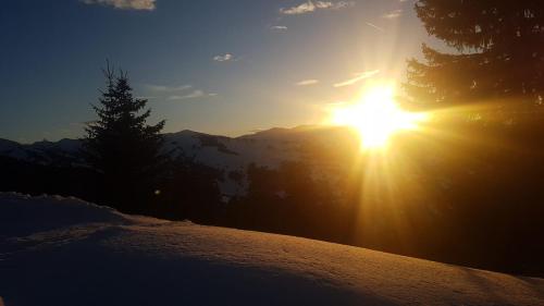 a sun setting on top of a snow covered mountain at Julia in Kaprun