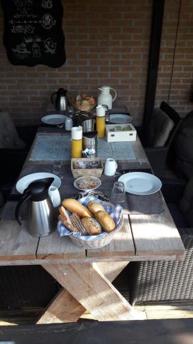 a wooden table with bread and other food on it at Bed & Breakfast De Schans in Makkum