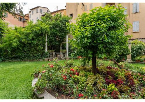 a garden with a tree and flowers in a yard at Phi Hotel Canalgrande in Modena