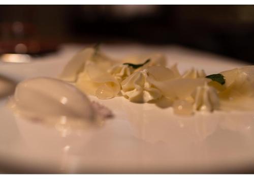 a white cake with white frosting and flowers on a plate at Phi Hotel Canalgrande in Modena