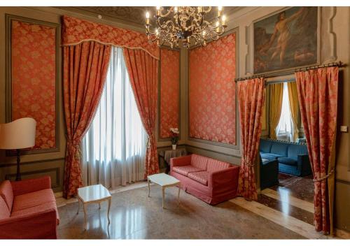 a living room with red furniture and a chandelier at Phi Hotel Canalgrande in Modena