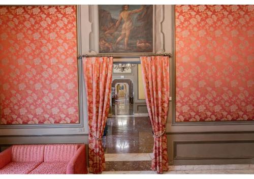 a hallway with orange curtains and a painting on the wall at Phi Hotel Canalgrande in Modena