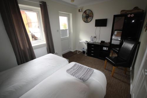 a bedroom with a bed and a desk and a chair at Red Lion in Swaffham