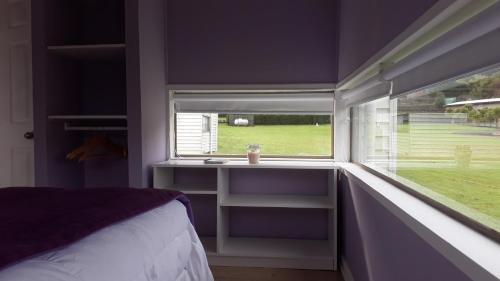 a bedroom with a window with a bed and a desk at Achibueno Lodge in Linares