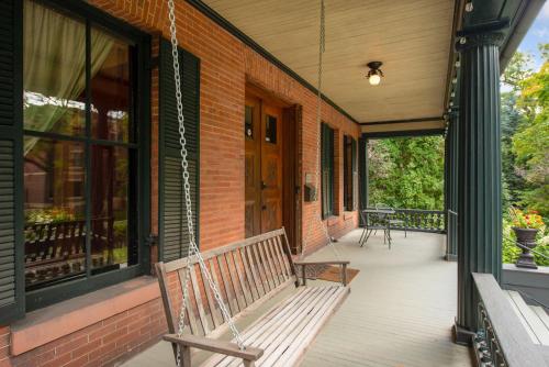 a porch with a swinging bench on a house at Historic District BnB in Saint Paul