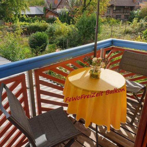 a table and chairs on a balcony with an umbrella at FeWoFreiZeit in Rheinau