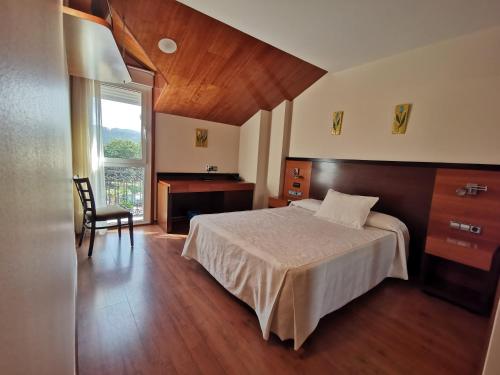 a bedroom with a bed and a desk and a window at Doade in Hio