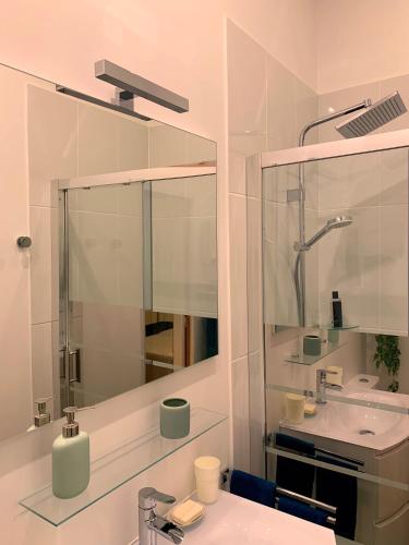 une salle de bain blanche avec un lavabo et un miroir dans l'établissement L'Art Studio hyper centre, à La Rochelle