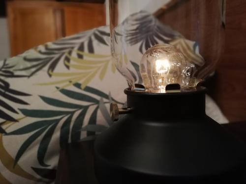 une lampe en verre sur une table à côté d'un canapé dans l'établissement LA ALDEA, à Llanes