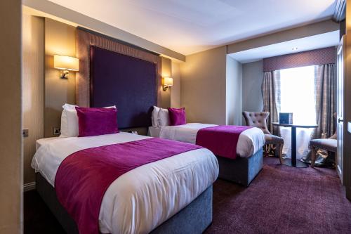 a hotel room with two beds and a window at Fir Trees Hotel in Strabane