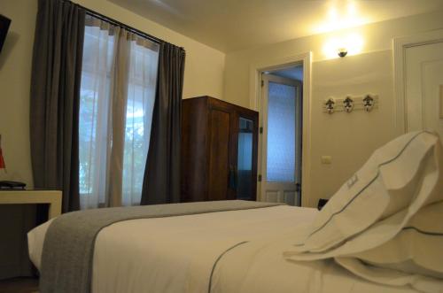 a bedroom with a white bed and a window at Hotel Villa Condesa in Mexico City