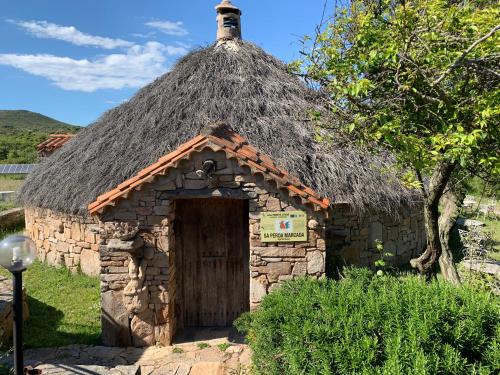 een klein stenen gebouw met een grasdak bij Agriturismo Sa Perda Marcada in Arbus