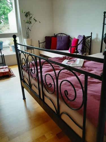 a bed with a black frame and pink sheets at Zimmer in Penthouse-Wohnung in Windisch