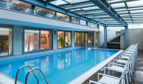 a swimming pool with chairs and a building at Terminal Palace & SPA in Rimini