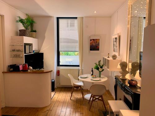 un salon avec une table et une petite cuisine dans l'établissement L'Art Studio hyper centre, à La Rochelle