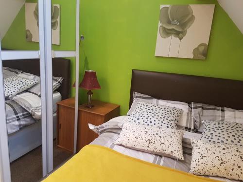 a bedroom with a bed and a green wall at ZenStay in Sunderland