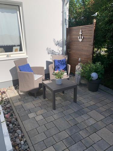 a patio with two chairs and a table and a window at Haus Vicus in Greifswald