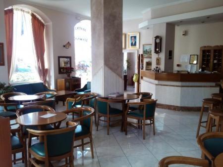 a restaurant with tables and chairs in a room at Diethnes in Larisa